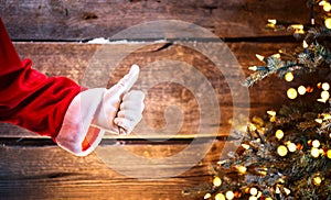 Santa Claus thumb up gesture over wooden background