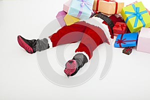 Santa claus too tired to lie on floor with many gift boxes