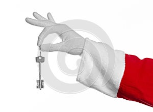 Santa Claus topic: Hand santa holds the keys to a new apartment or a new house on a white background