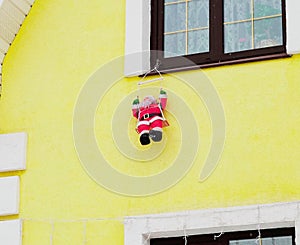 Santa Claus toy is hanging on the window. Christmas decoration of the house