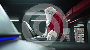 Santa Claus training at the gym on Christmas Day. Santa Claus running in machine treadmill at fitness gym club