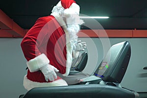 Santa Claus training at the gym on Christmas Day. Santa Claus running in machine treadmill at fitness gym club.