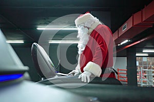 Santa Claus training at the gym on Christmas Day. Santa Claus running in machine treadmill at fitness gym club.