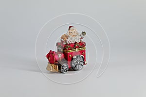 Santa Claus is traveling on a small red toy train.