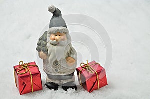 Santa Claus with two red Parcels on Snow Background, horizontal