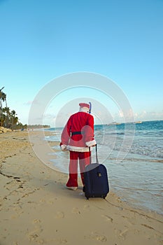 Santa Claus is on vacation on a tropical beach