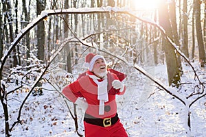 Santa Claus walk in the winter mountains. Christmas time with snow.