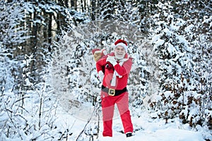 Santa Claus walking to the winter forest with a bag of gifts, snow landscape. Happy New Year. Postcard, greeting card.