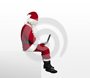 Santa claus watching laptop and sitting