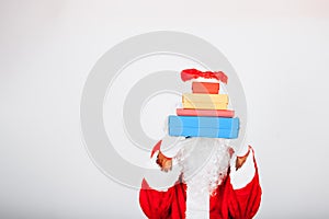 Santa Claus on white background hands out colored gift packages that cover his face