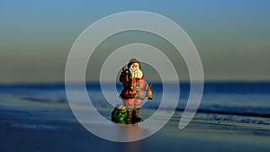 Santa Claus on winter holidays on hot beach. Happy New Year and merry Christmas travel, tropical vacations concept.