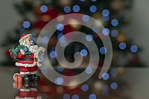 Santa claus on wooden background with christmas tree in background