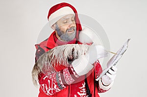 Santa Claus writes with a pen in a notebook