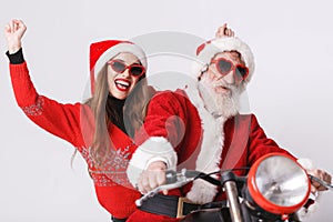 Santa Claus And Young Mrs. Claus Riding A The Motorcycle