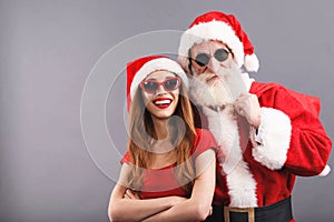 Santa Claus And Young Mrs. Claus Standing On The Gray Background