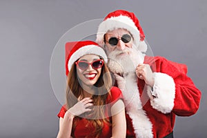 Santa Claus And Young Mrs. Claus Standing On The Gray Background