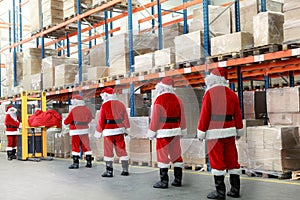 Santa clauses in the line for gifts in warehouse