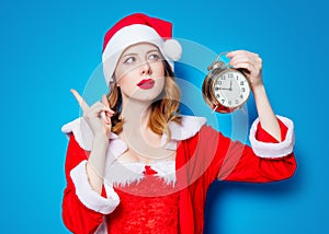 Santa Clous girl in red clothes with alarm clock