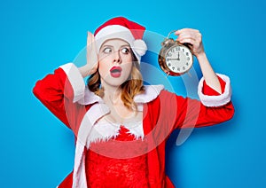 Santa Clous girl in red clothes with alarm clock