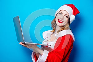 Santa Clous girl in red clothes with laptop computer
