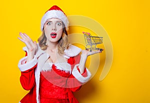 Santa Clous girl in red clothes with shopping cart