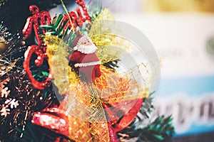 Santa doll on a Christmas tree that is decorated in celebration