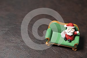 Santa doll model sitting in miniature green fofa photo