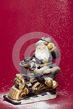 Decorative Santa figurine and snowing on red background