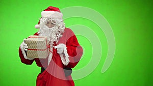 Santa gets a gift from a bag on green background