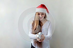 Girl in Santa hat with christmas balls in the hands