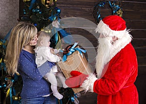 Santa gives a gift to mum with baby