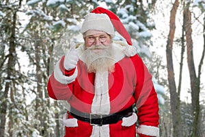 Santa giving thumb up outdoors.