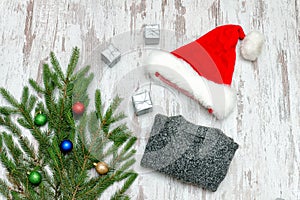 Santa hat, decorated with fir branch and a gray sweater on a woo