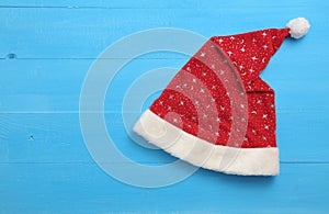 Santa hat with stars on blue wooden background