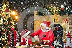 Santa helper. Happy father and son in Santa hat with cookies have a Christmas. Christmas interior. Happy new year