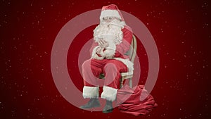 Santa laughing out loud as he talks on his cell phone on red background with snow