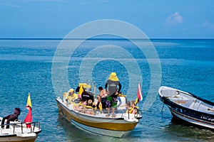 SANTA MARTA, COLOMBIA - OCTOBER 10, 2017: Unidentified tourists sailing in a boat in a caribean beach. Taganga, Colombia