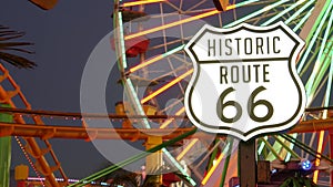 SANTA MONICA, LOS ANGELES, USA - 28 OCT 2019: Iconic road sign glowing, historic route 66. Famous california symbol, pier of