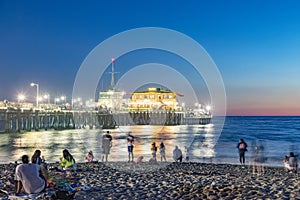 people enjoy the ocean park at Santa Monica pier by night