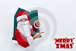 Santa popping out from hole and pointing to copy space