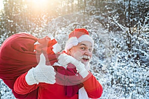 Santa portrait close up. New year Christmas concept. Santa Claus pulling huge bag of gifts on white nature background.