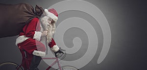 Santa riding a bicycle and carrying gifts