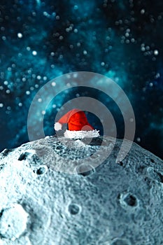 Santa`s hat on the moon against the background of the night starry sky