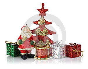 Santa standing with red Christmas tree, gift boxes and toy drum