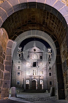 Santa Teresa church view through gate of the walls at night in Avila, Spain