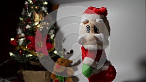 A santa toy dancing against christmas tree. Fun dancing video concept during Xmas celebration