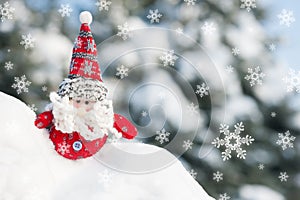 Santa toy in forest with snowfall