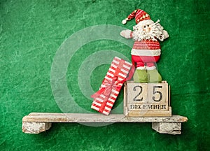 santa toy on a shelf, wooden calendar with 25 december date, christmas banner, copy space for promo or ad