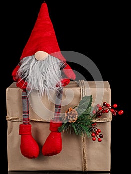 Santa toy sitting on gift box  on black