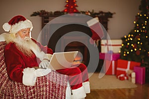 Santa using laptop on the couch at christmas